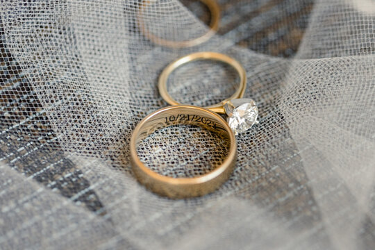 Close-up of wedding rings with a date engraving on a veil