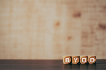 There is wood cube with the word BYOD. It is an abbreviation for Bring Your Own Device as eye-catching image.