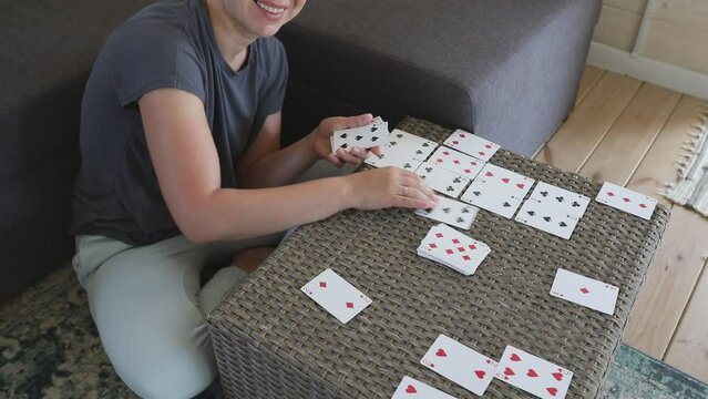 Woman Plays Cards On A Wicker Table Indoors