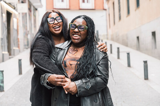 Two friendly women laughing together on the street