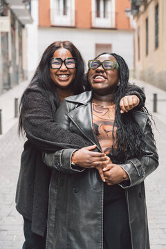 Two friendly women laughing together on the street