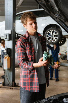 A man repairs a car in the garage