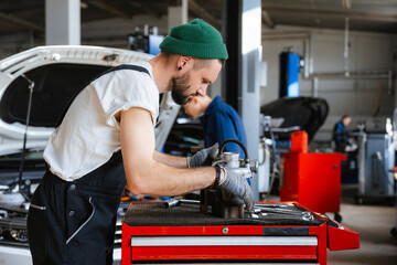 A man inspects a car spare part
