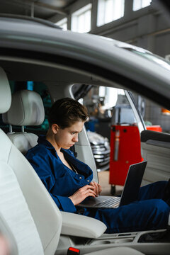 An auto mechanic performs computer diagnostics of a car