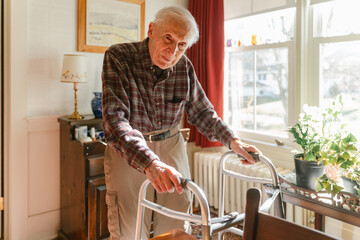 elderly man/ senior citizen walking in his home 