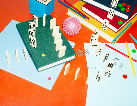 Curvy playful tactic row of dominos in office desk and hard flashlight