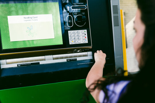 young woman getting cash at drive through ATM