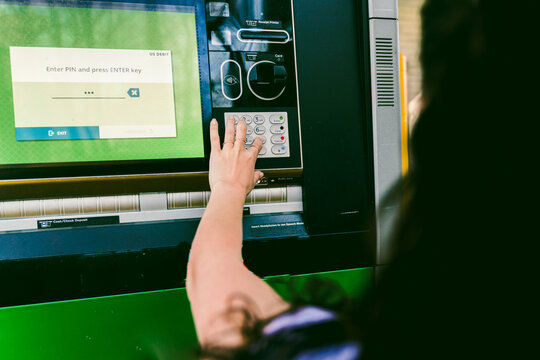 young woman getting cash at drive through ATM