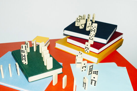 Curvy playful tactic row of dominos in office desk and hard flashlight