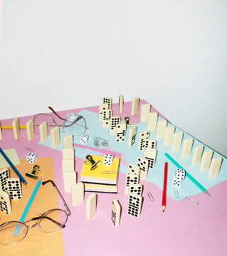 Curvy playful tactic row of dominos in office desk and hard flashlight