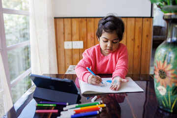 Little girl drawing with sketch pen