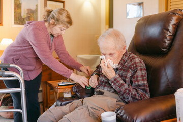caregiver looking after elderly man in his home 