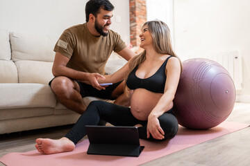 Happy pregnant couple together at home.