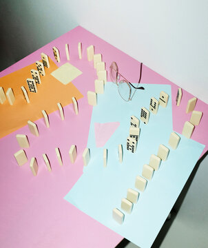 Curvy playful tactic row of dominos in office desk and hard flashlight