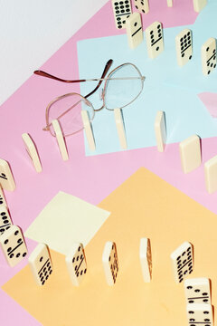 Curvy playful tactic row of dominos in office desk and hard flashlight