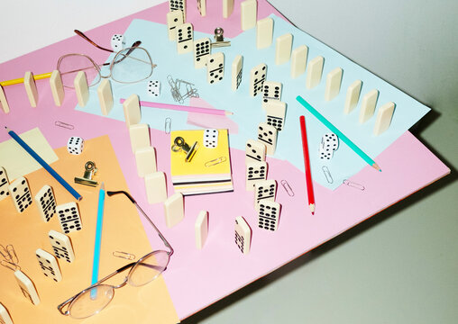 Curvy playful tactic row of dominos in office desk and hard flashlight