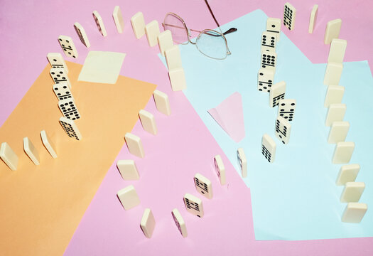 Curvy playful tactic row of dominos in office desk and hard flashlight