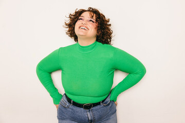 Joyful curvy woman in green turtle neck looking upward