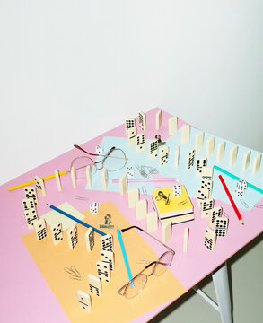 Curvy playful tactic row of dominos in office desk and hard flashlight