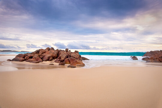 Wave rolling onto sand south west beach