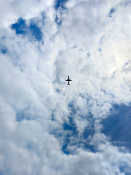 Airplane flying over blue sky with white clouds