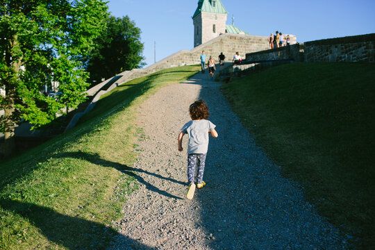 Kid running on gravel path in park in Quebec City