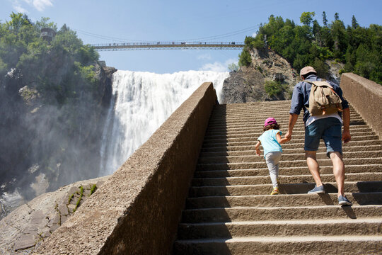 Back of father and kid walking up stairs in  Montmorency Falls
