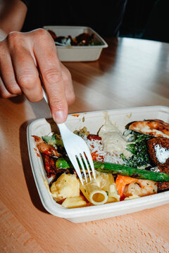 man eating assorted food from a container