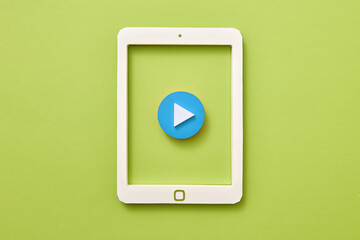 Handcraft paper tablet with blue button play over green background