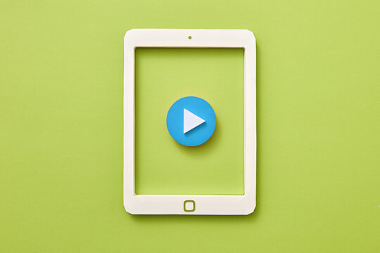 Handcraft paper tablet with blue button play over green background