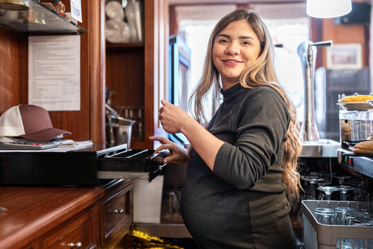 Expectant mother serving at a cozy bar