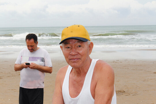 Older asian man is pictured on the beach
