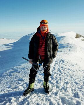 a happy man on top of Mount Rainier mountain after summiting