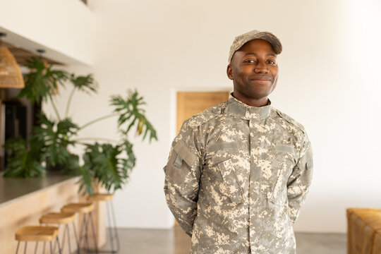 African American young soldier in military uniform standing indoors, smiling confidently - Powered by Adobe