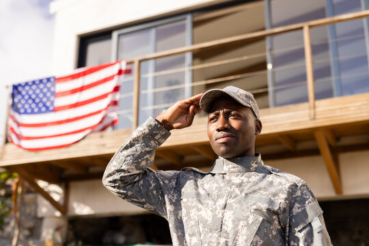 Young African American soldier in military uniform saluting