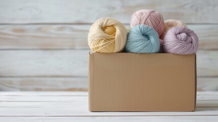 A cardboard box filled with dyed yarn skeins in soft pastel colors