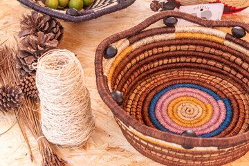 overhead view of a still life with a colorful handmade basket made of fique