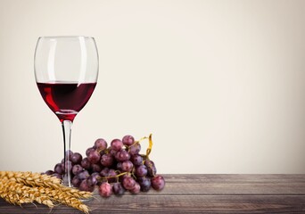 Cup of wine and decoration grapes and wheat