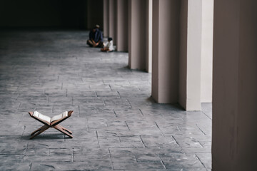 Islamic concept - The Holy Al Quran at beautiful mosque with written Arabic calligraphy meaning of Al Quran and rosary beads or tasbih, Arabic word translation: The Holy Al Quran (holy book of Muslim)