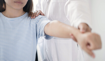 Fototapeta premium Female physiotherapists provide physical assistance to patients with shoulder injuries massaging their shoulders for muscle recovery in the rehabilitation center. Physiotherapy concepts