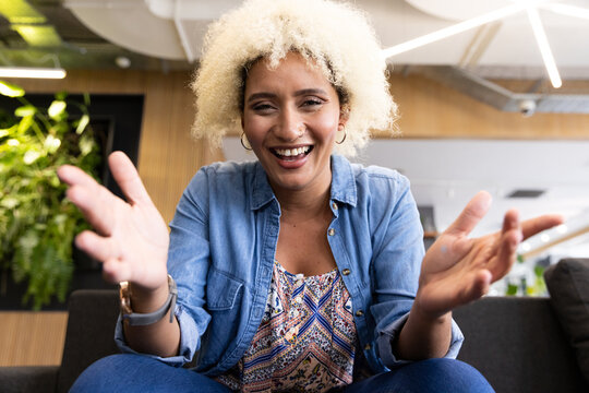 Biracial young woman smiling on video call in business office