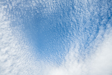 Beautiful blue sky with high Cirrocumulus white clouds, textured nature background
