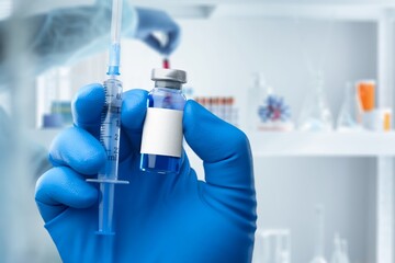 Medical worker filling a syringe with vaccine booster