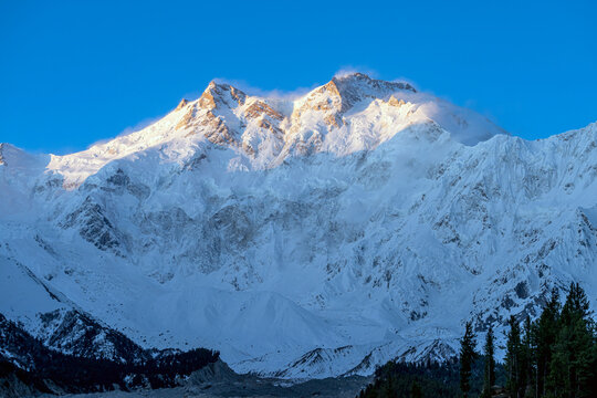 First morning light touch a Nanga Parbat, meaning "naked mountain" in Urdu and locally called Diamer, or "King of the Mountains," Located just southeast of the northernmost bend of the Indus River.