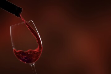 Poring tasty alcohol red wine in glass