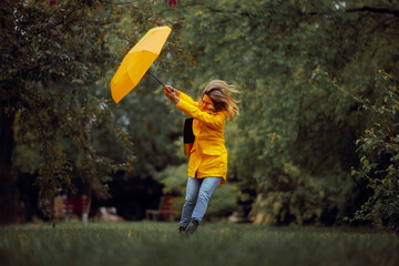 Woman Fighting Wind Blow During a Rainstorm Tempest. Strong windy bad weather being dangerous and...