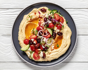 Greek hummus with veggies, olives, feta on plate