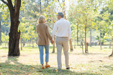 Fototapeta premium Elderly couple lifestyle concept. Husband and wife and sit walking in the park.
