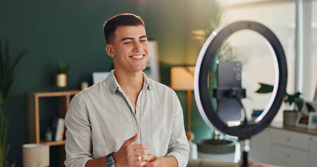 Man, light and smartphone for broadcast in home, smile for notification or announcement. Online, male influencer and vlogging in house with mobile, creative review for audience with media technology
