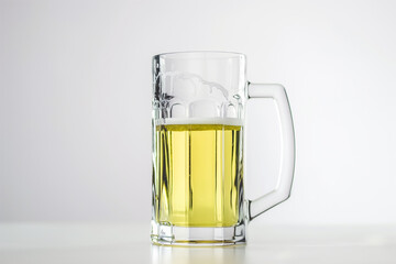 A glass mug filled with a golden yellow beer, topped with a white foam.